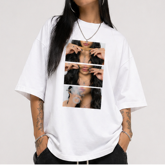 Person wearing a white oversized t-shirt with graphic design and black pants on a plain background